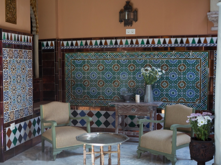 central patio and a corridor formed by columns and an intricately coffered ceiling.