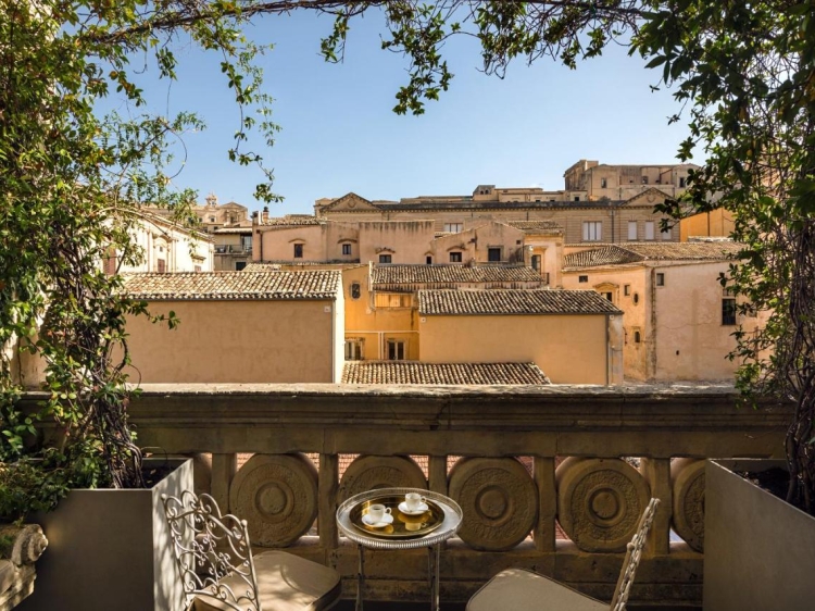 Balcony with panoramic view of rooftops in Seven Rooms Villadorata in Noto